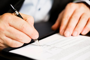 Photo of a person signing a document