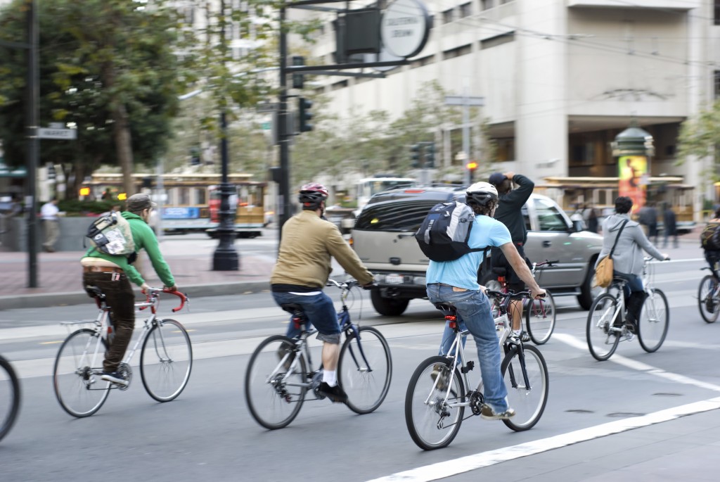 Environmentally conscious bikers in traffic in San Francisco, California. Motion blur on the subjects - faces unrecognizable.